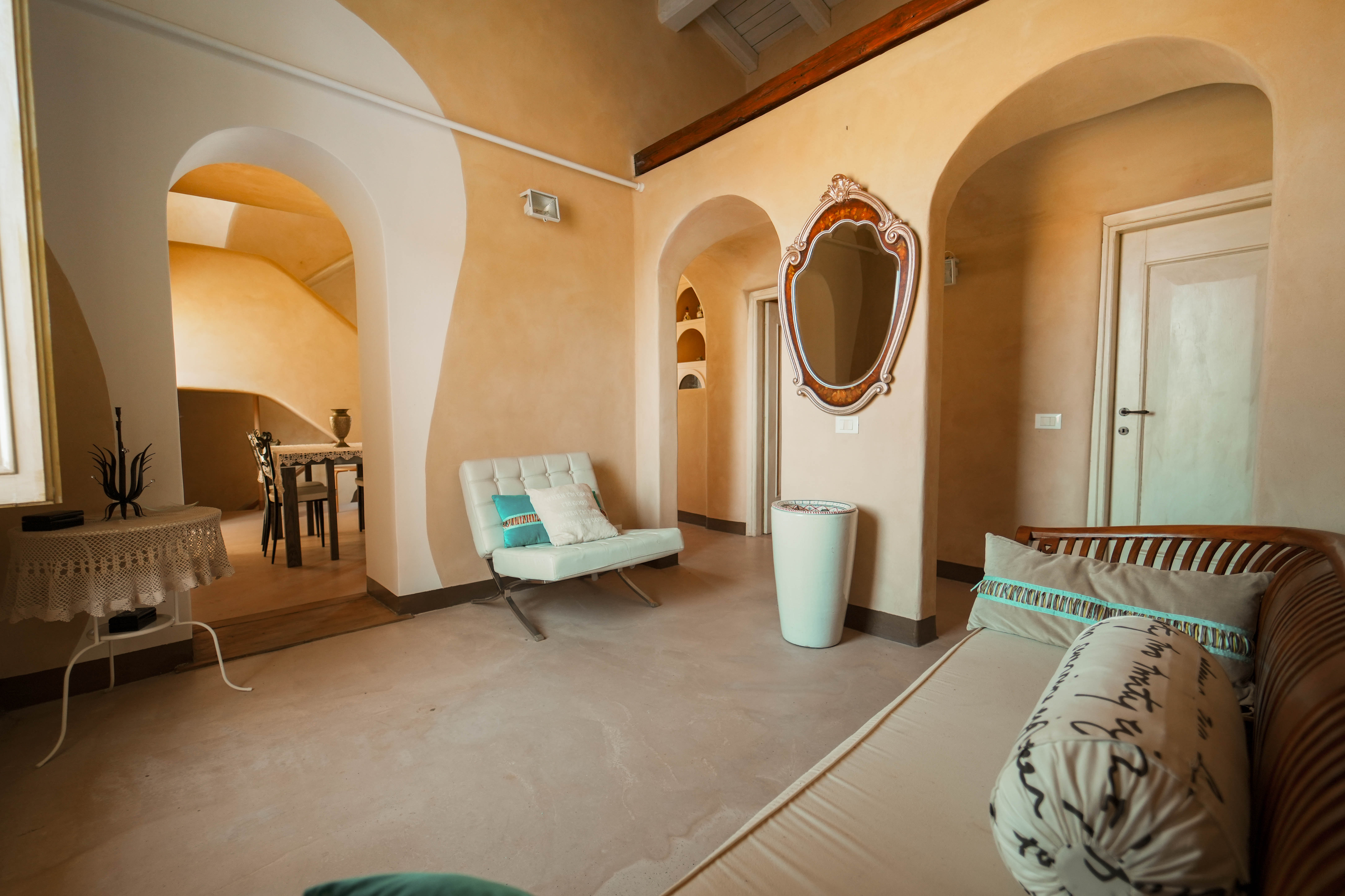 Soggiorno di una casa con archi e travi, da proporre in vendita